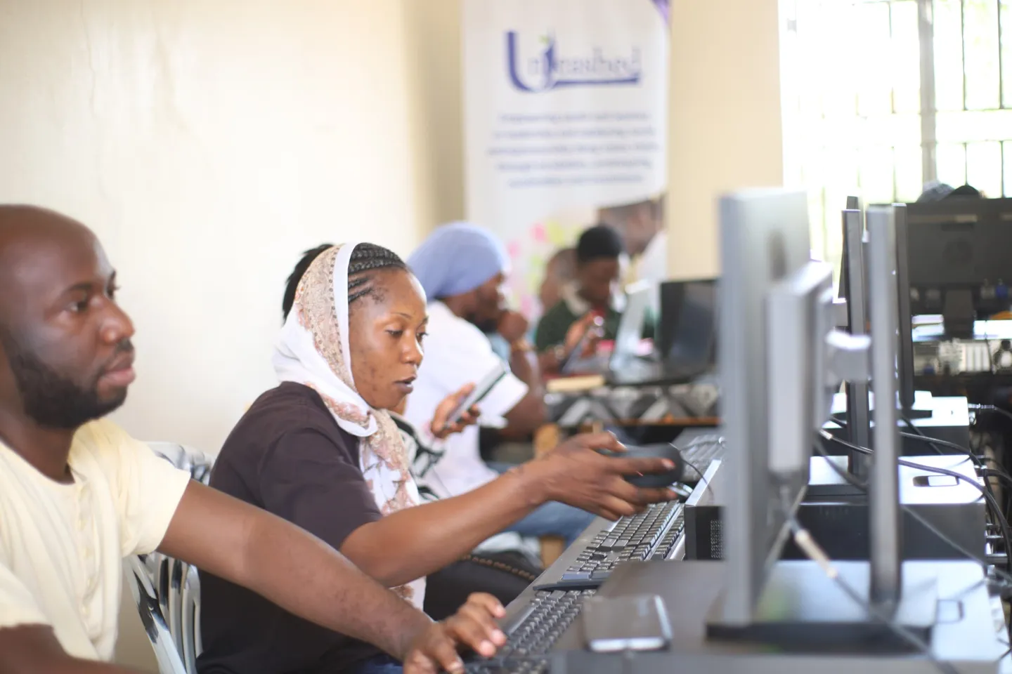 group of men and women taking training on digital tools in uganda