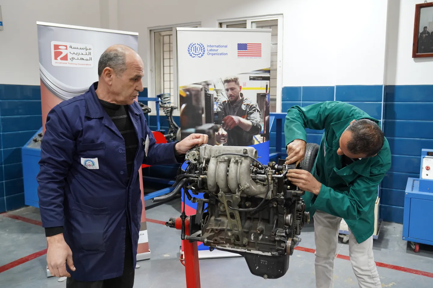 2 workers fixing a car engine