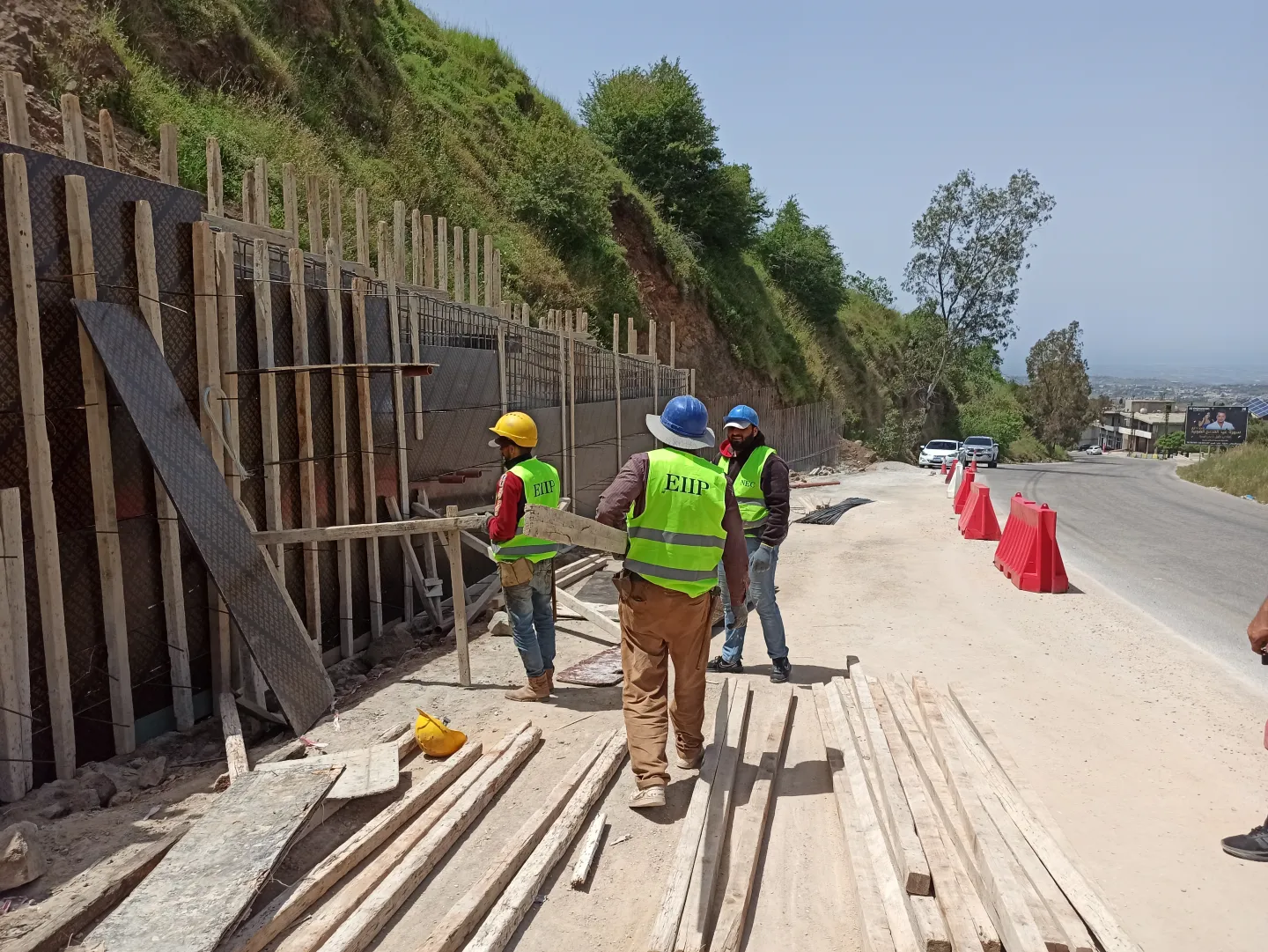 workers fixing a wall on the roads