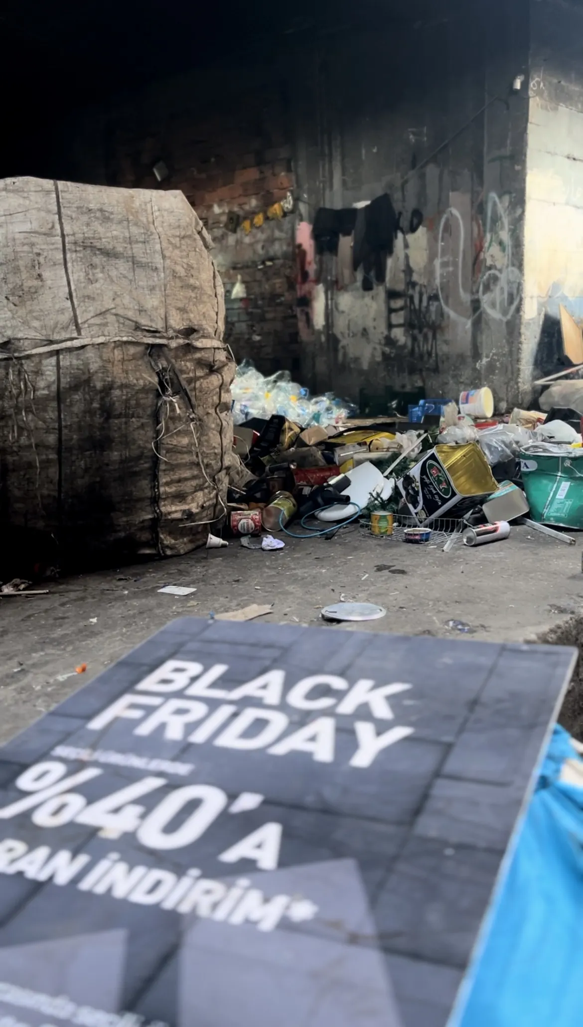 Black Friday signage, laying on street against pile of garbage, in Turkiye