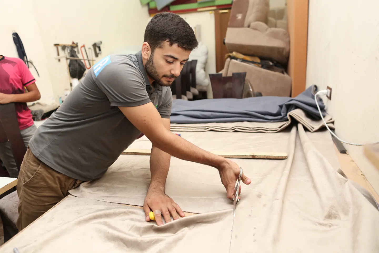 man cutting a curtain clothe