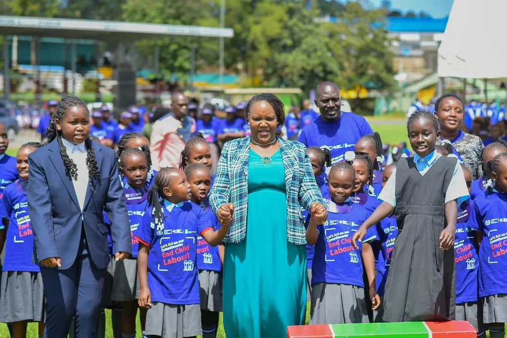 Government official holds hands with children wearing a world day t-shirt
