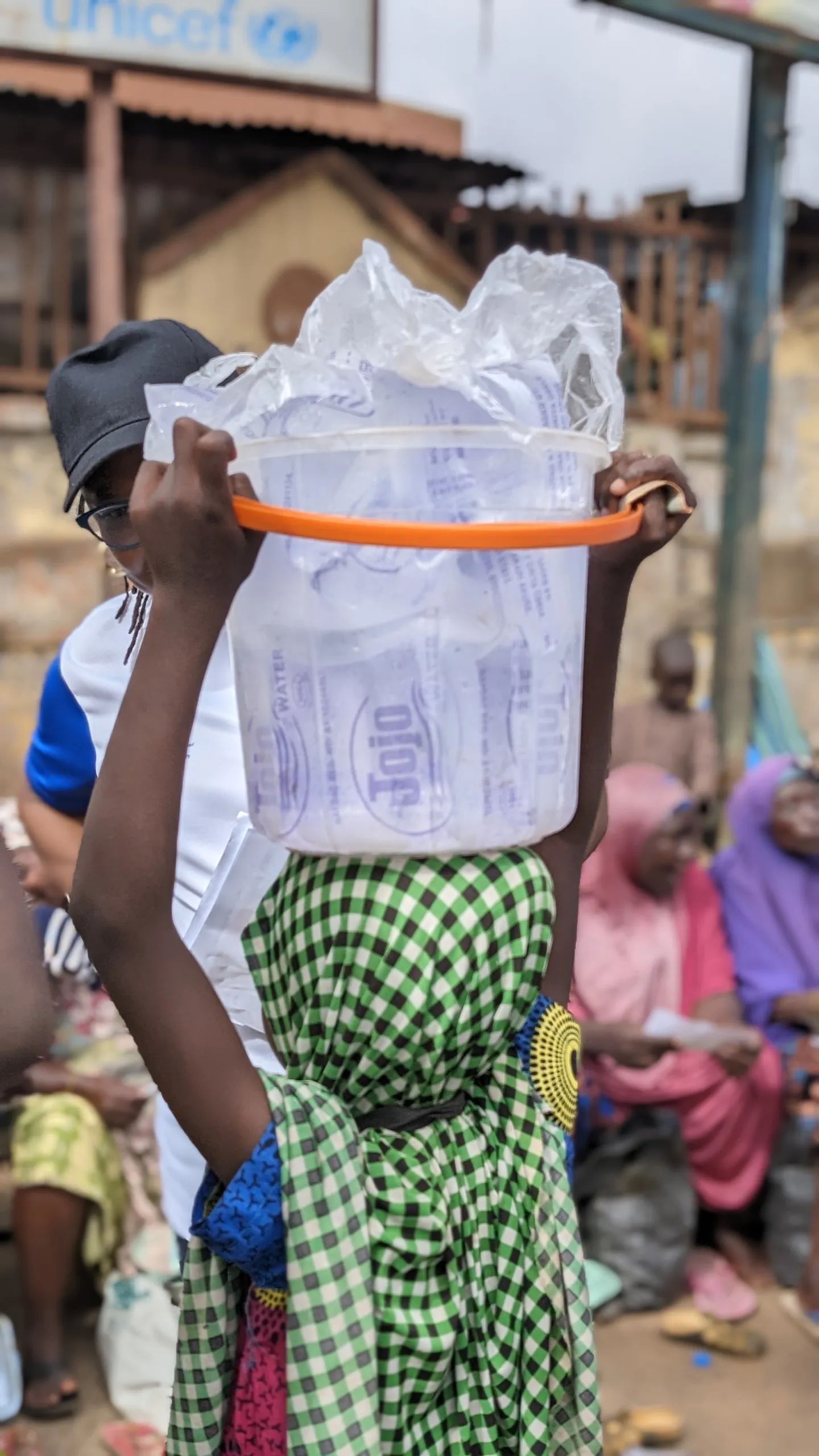 ILO staff engaging a young lady hawking satchel water at Oba Adesida market, Akure, Nigeria.