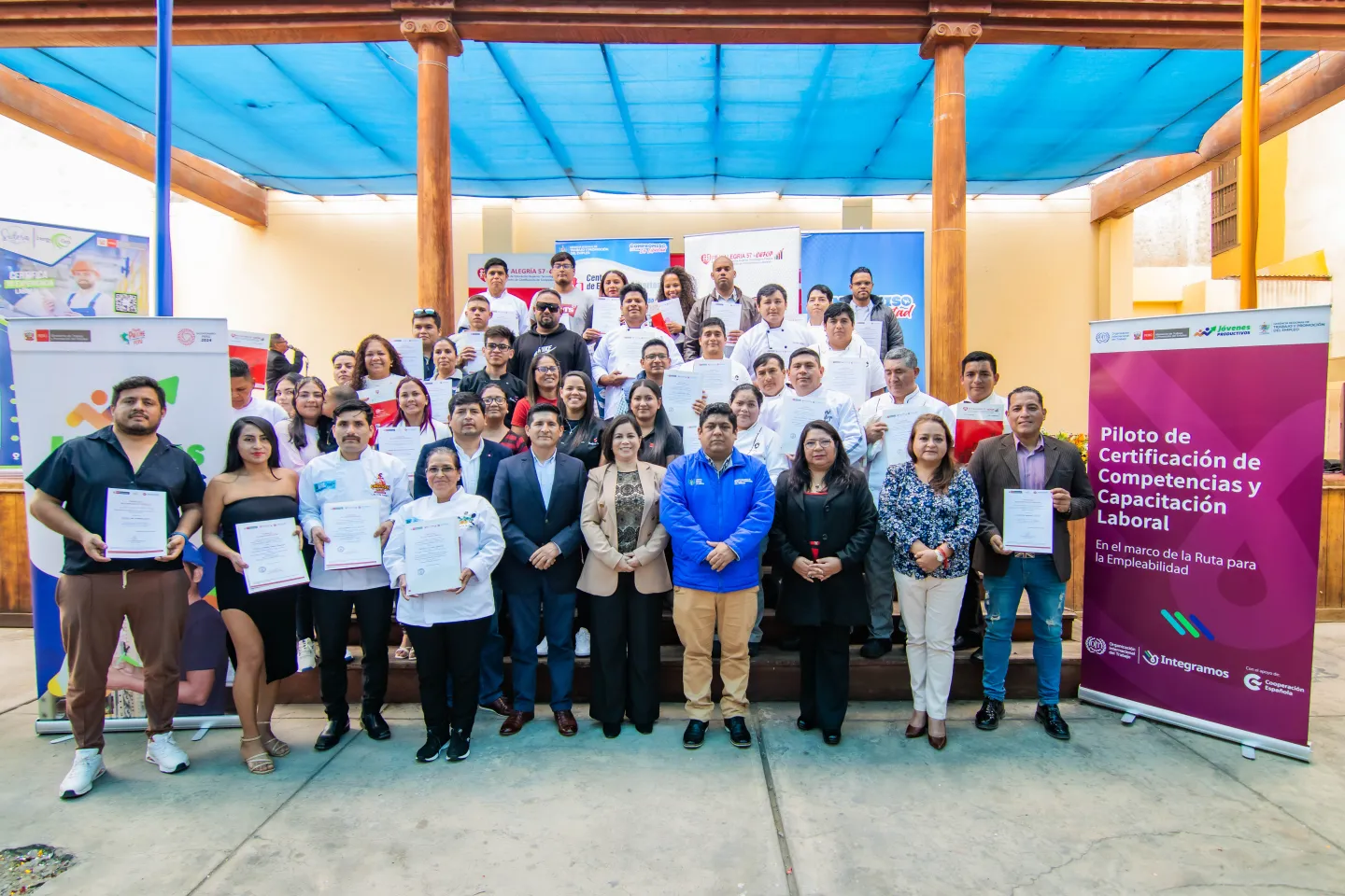 Personas posando en grupo con sus certificaciones laborales