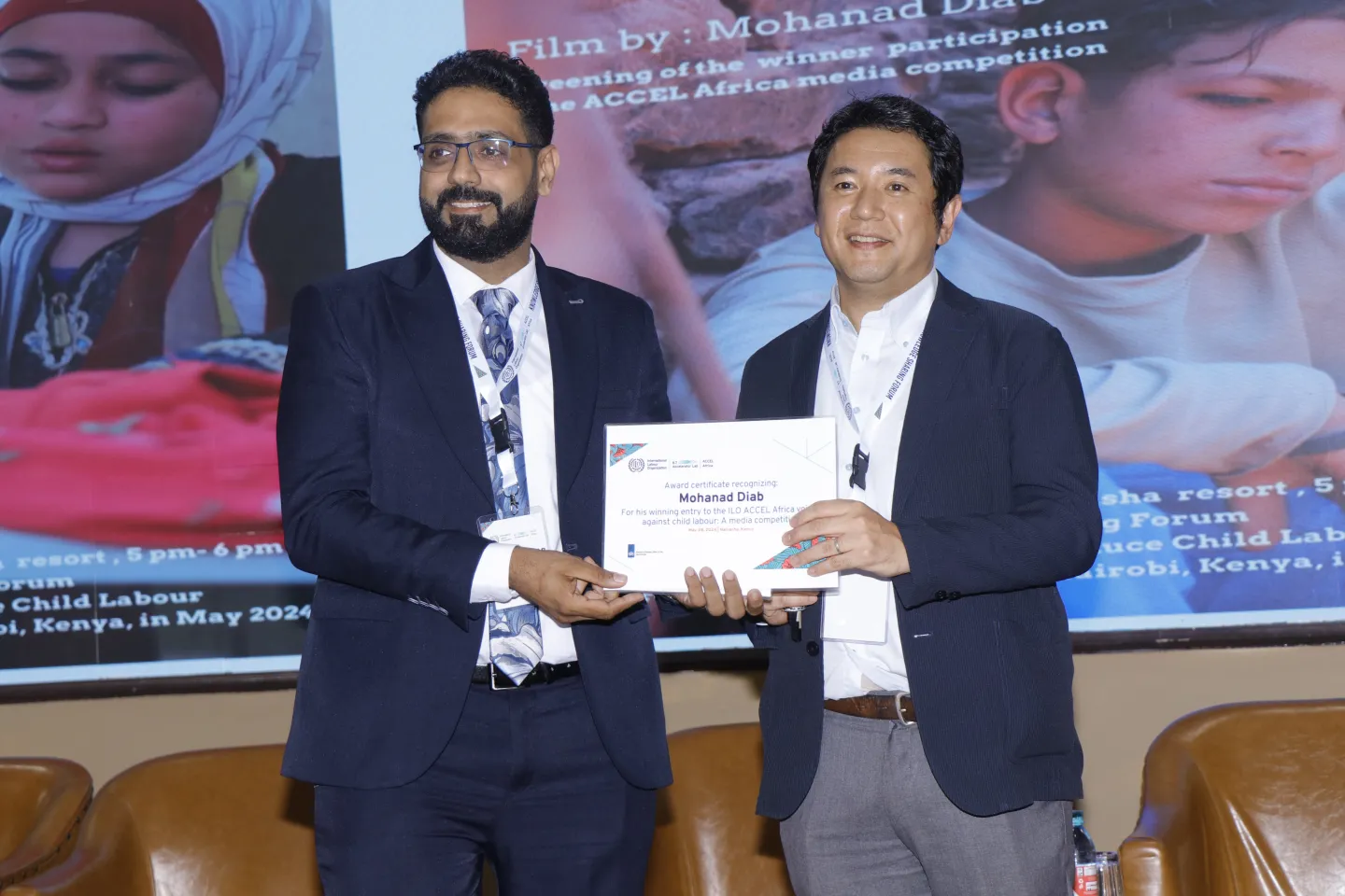 A journalist gets a diploma of participation from an ILO staff