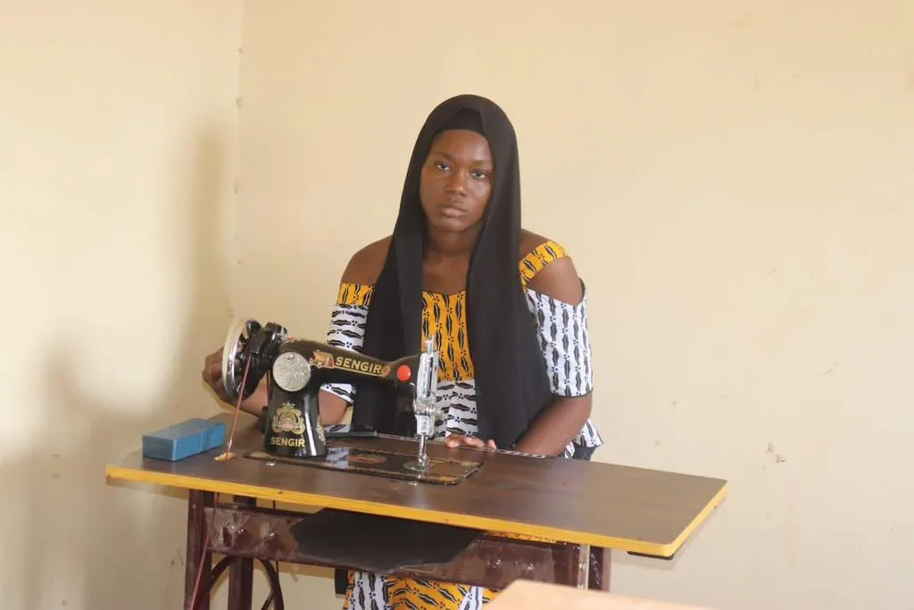 Marie poses with her sewing machine