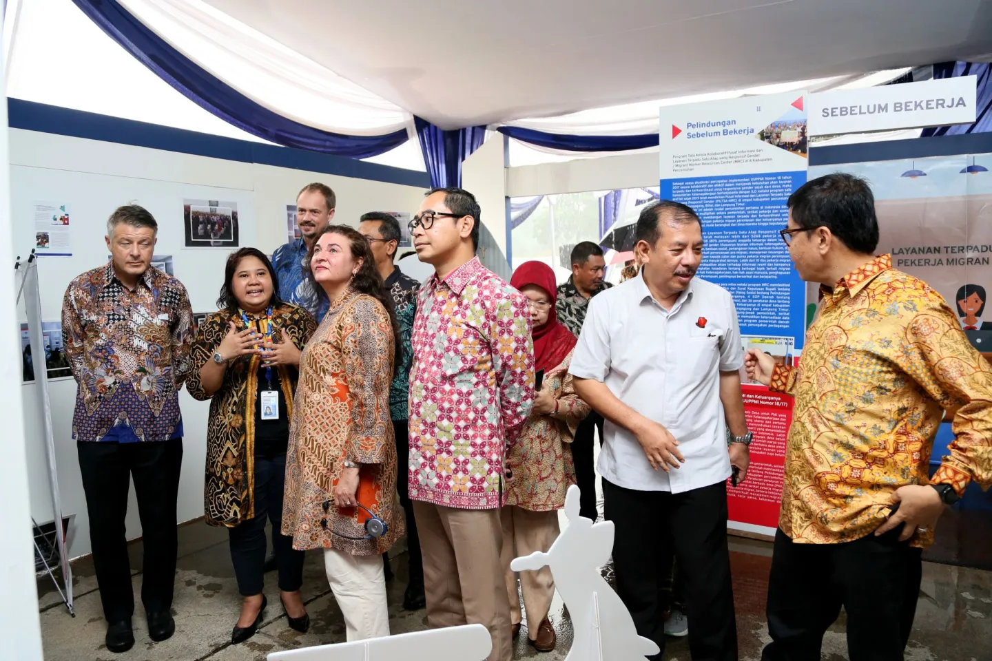 High level participants of the launch of PROTECT Indonesia visit the exhibition on cycles of labour migration.