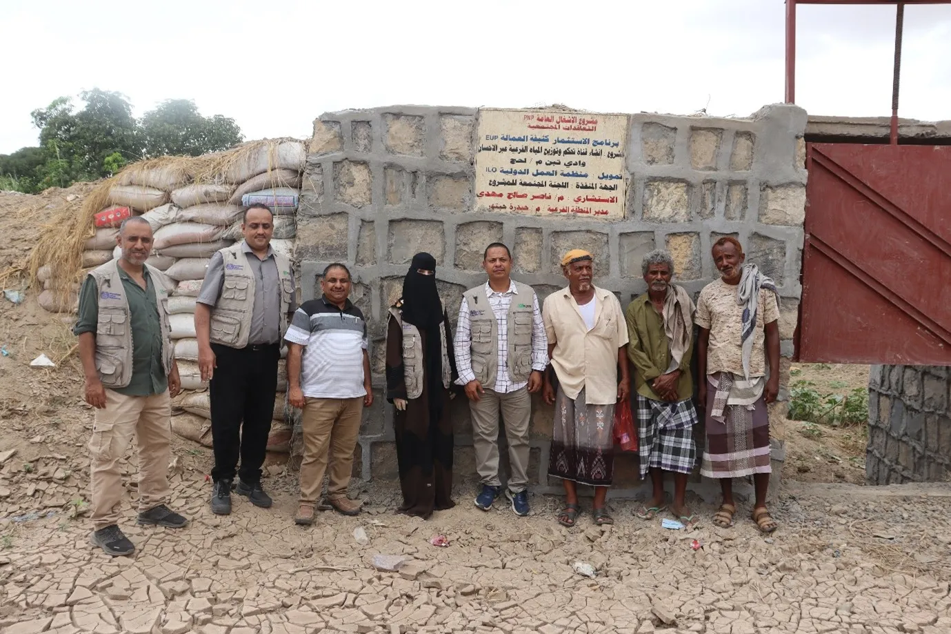 a group image of men and women in front of a project site