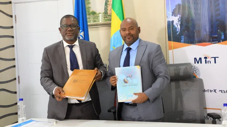 men signing MoU