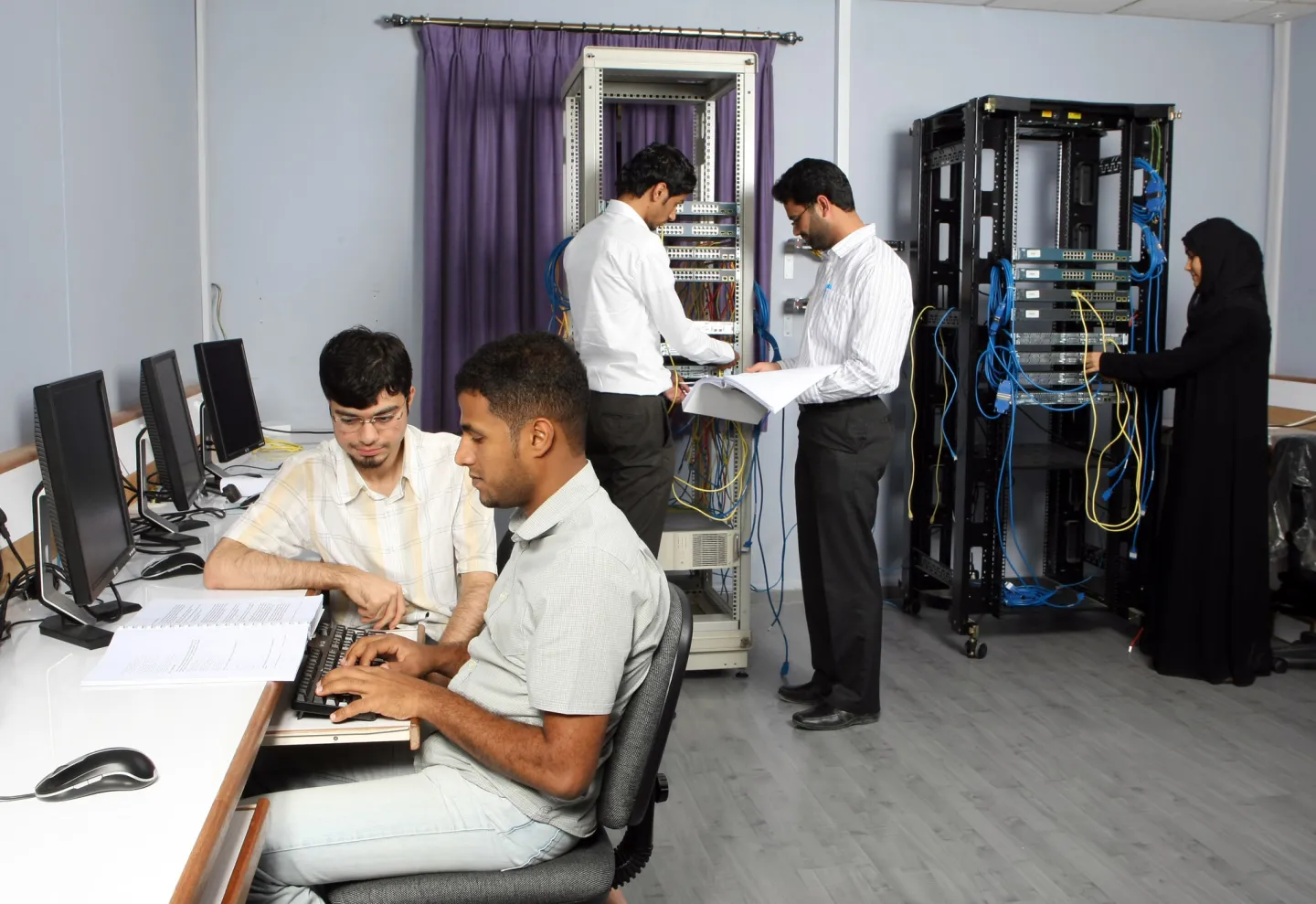  Men and women are seen at a technology training center.