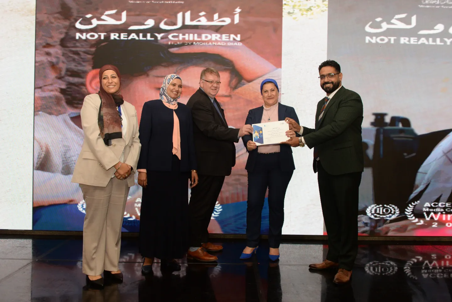 ILO Director gives a certificate to award winning journalist