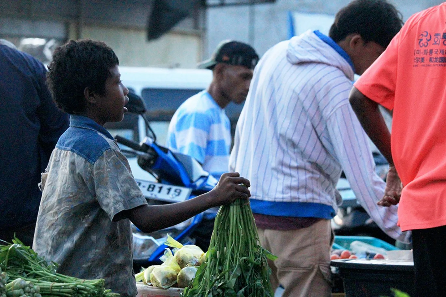 Elizino de Deus helps her mother selling vegetables in Dili, Timor-Leste.