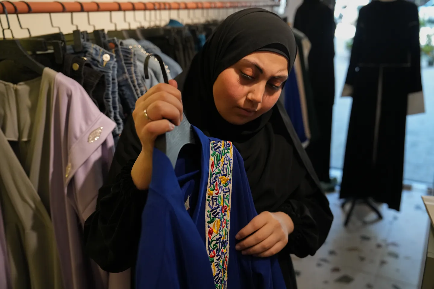 Shop assistant shows clothes belonging