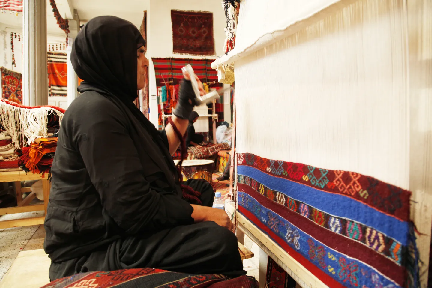 An Iraqi woman making a traditional carpet at a shop south of Baghdad.