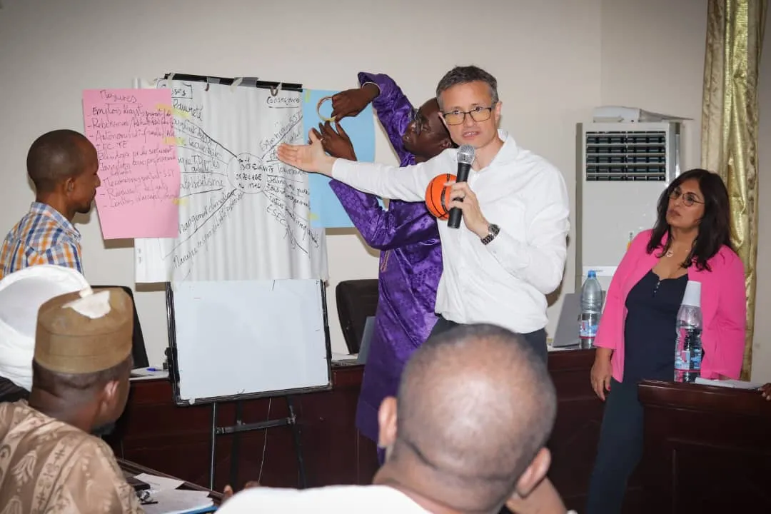An ILO staff shows a table with his hand, to highlight some important elements of the lecture