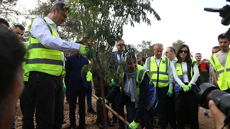 ILO Country Coordinator for Iraq Maha Kattaa, and Governor of Duhok Ali Tatar plant a tree at the afforestation site