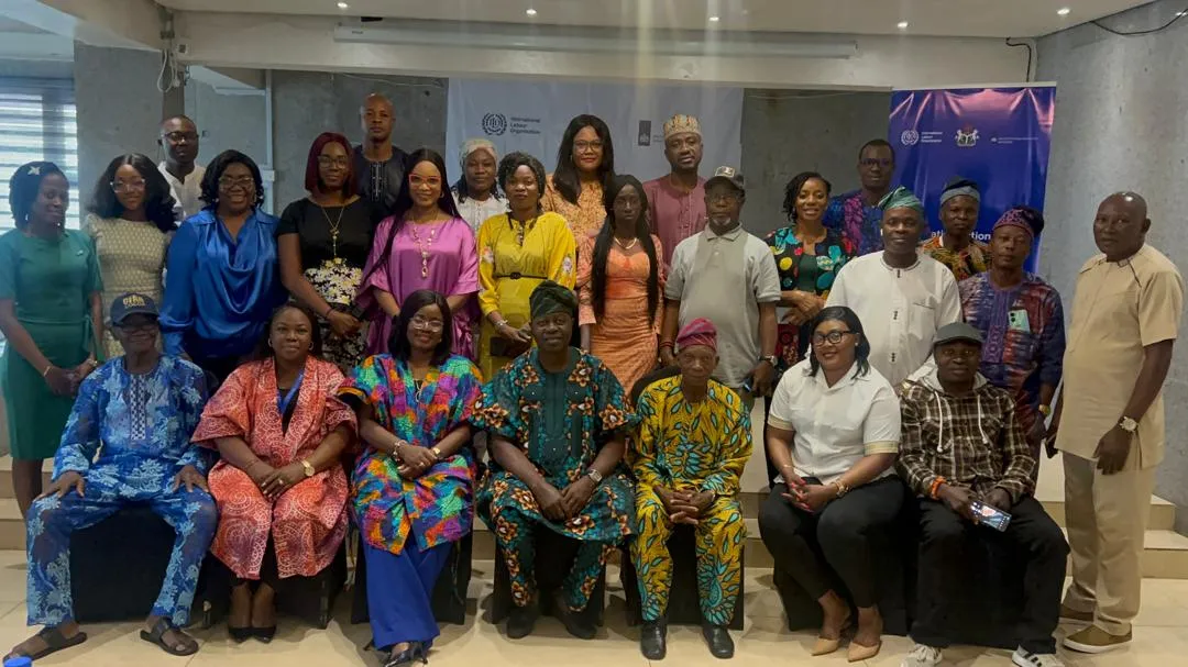 Participants to a workshop pose for a group picture in colourful Nigerian dresses
