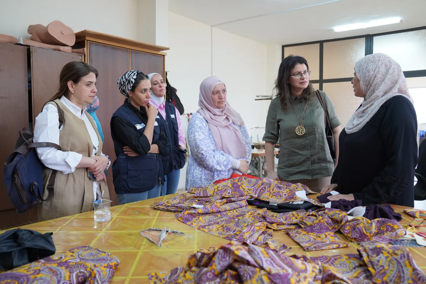 Regional Director Jaradat, ILO delegation members, and Miami Business Center representative discussing textile training module with EIIP beneficiary trainees at Jerash Women’s Association 