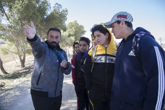 man showing direction to young people