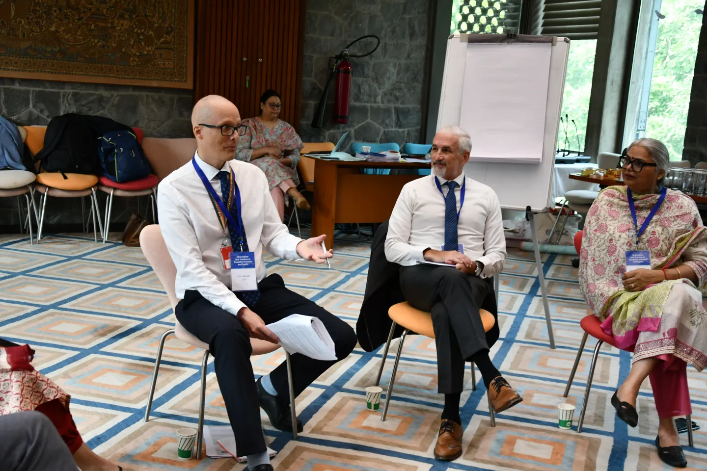 Men and a woman sitting together in a conference room