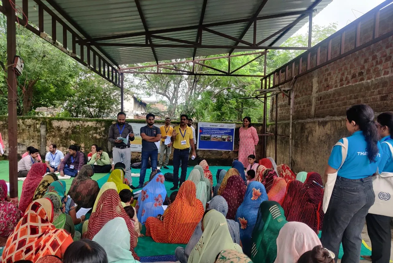 Women sitting on the ground for a training in a village