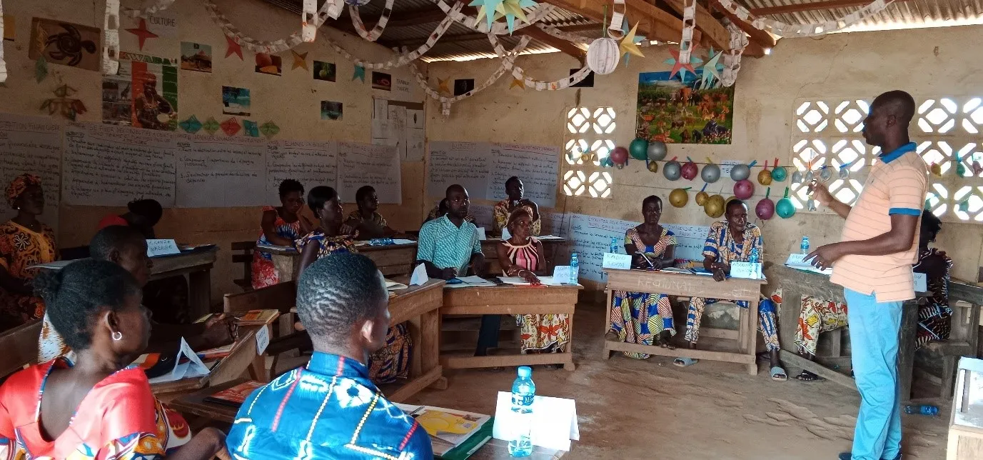 Community members listen to trainer in a classroom