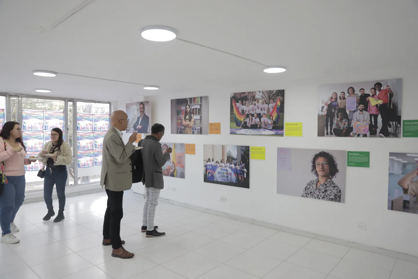 Fotografía de los asistentes a la exposición observando las diversas fotografías
