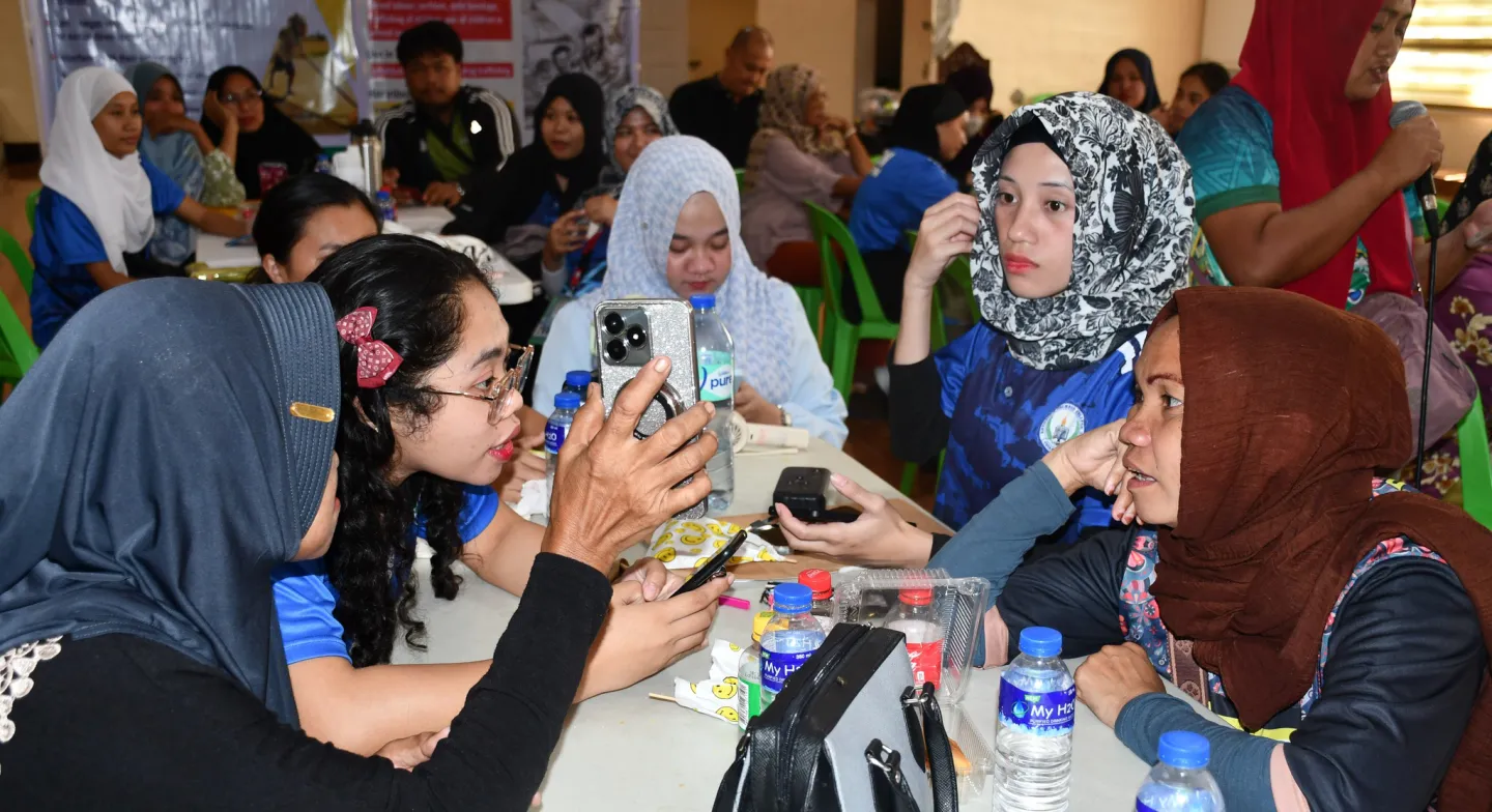 five women use their mobile phones to collect data on child labour