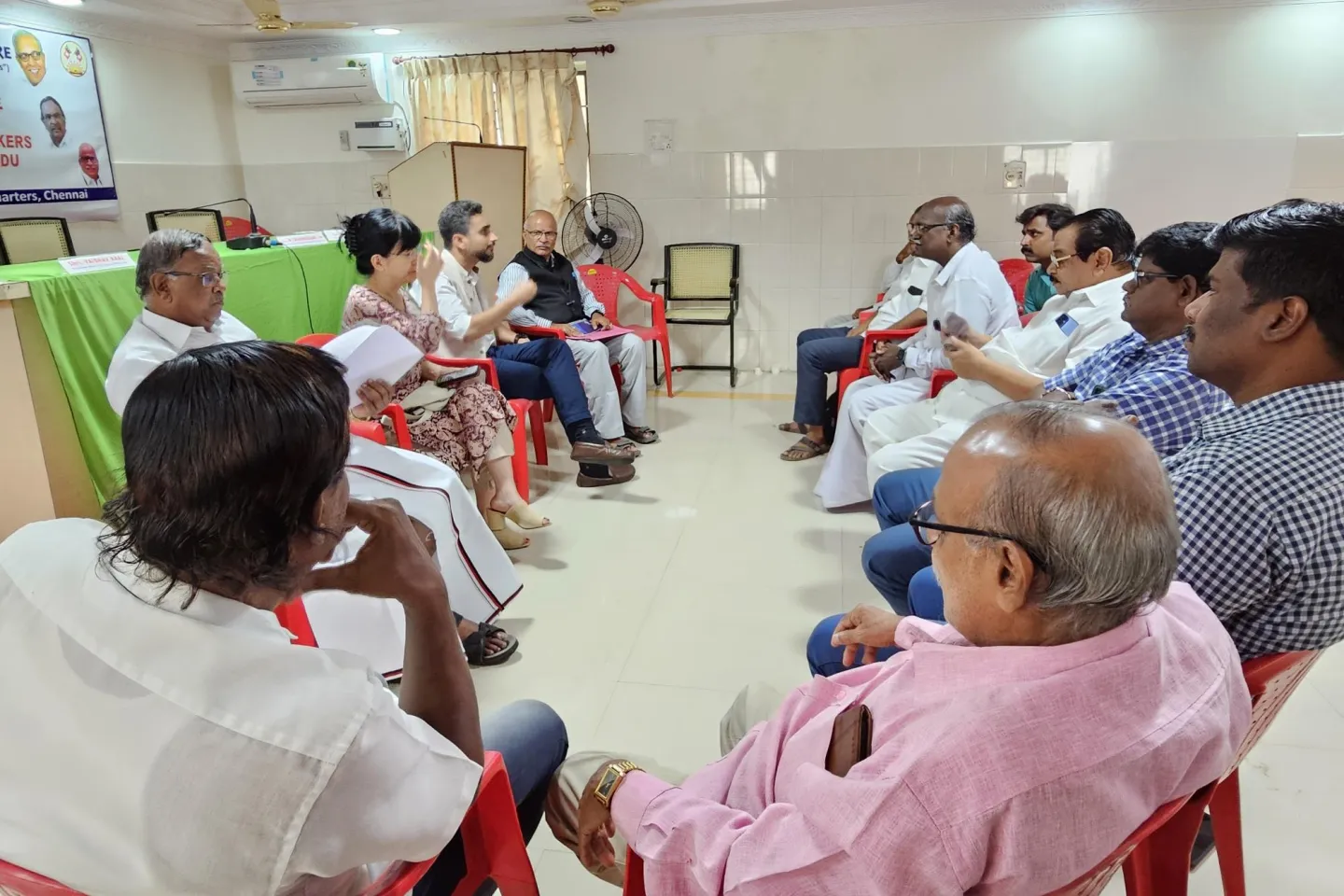 One woman and several men sitting together for a discussion