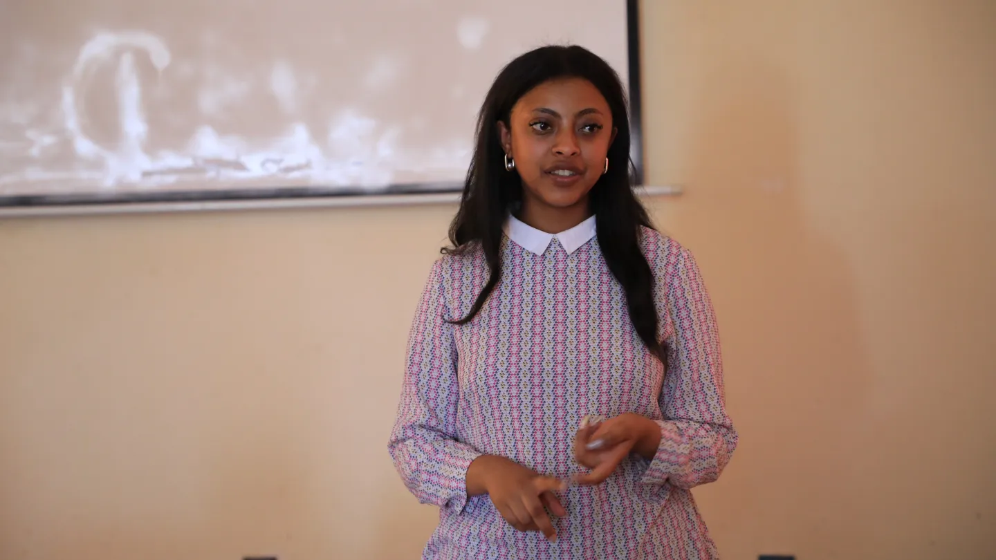 A young woman speaking infron of an audience