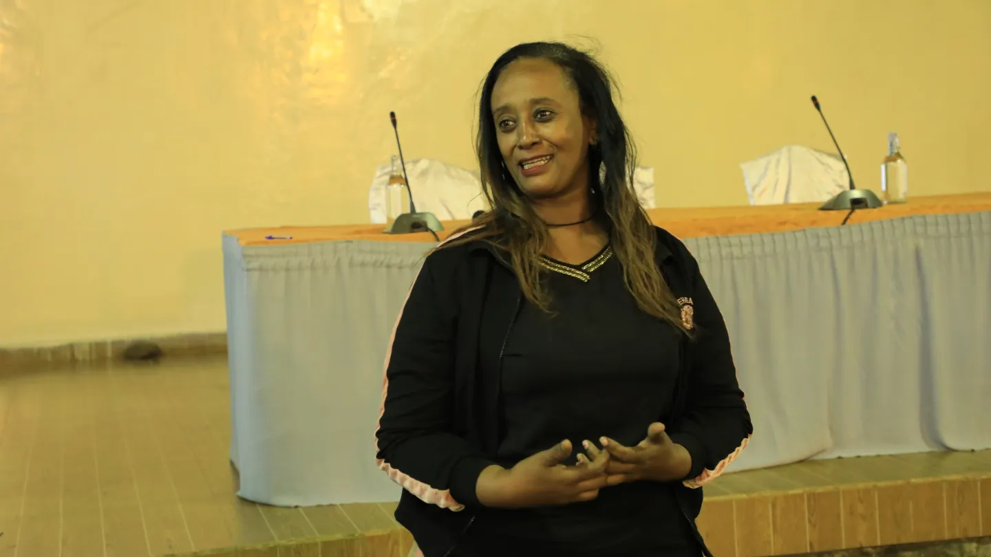 A woman speaking infront of an audience. 