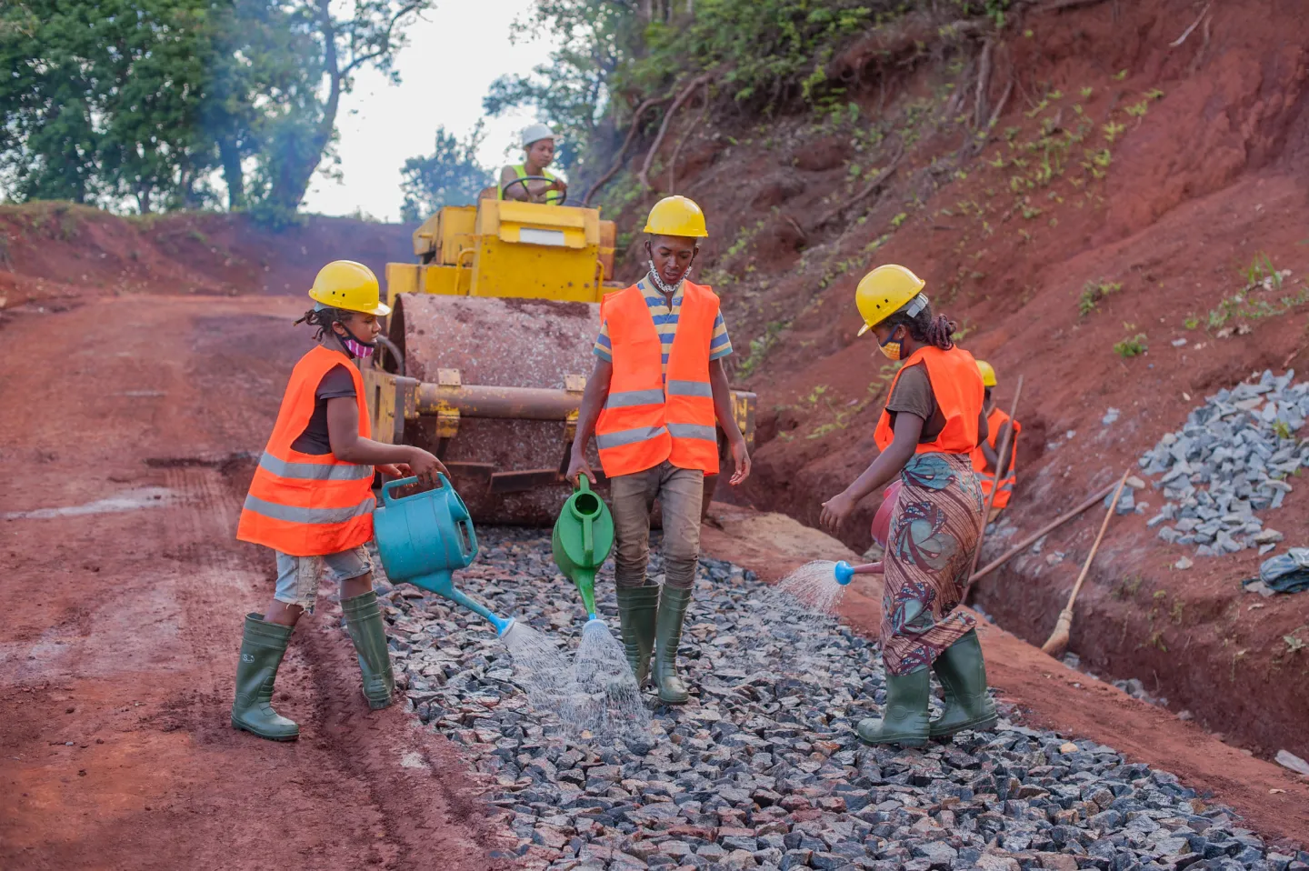 construction workers paving a road in Africa