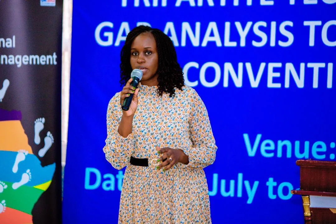 A woman speaking infront of an audience. 