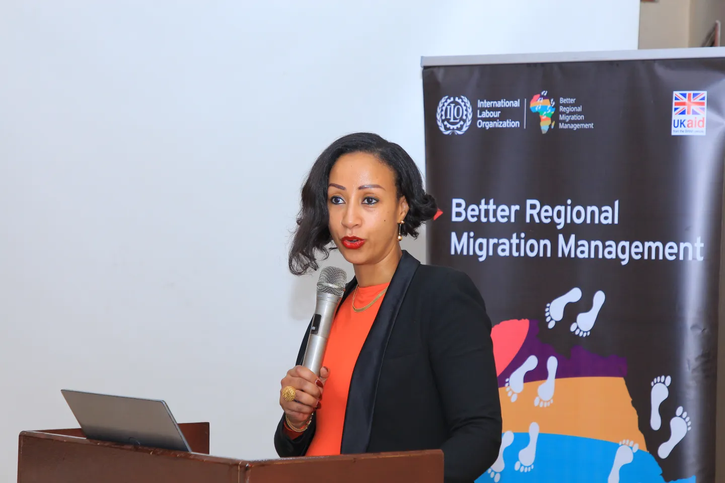 A woman speaking infront of an audience. 
