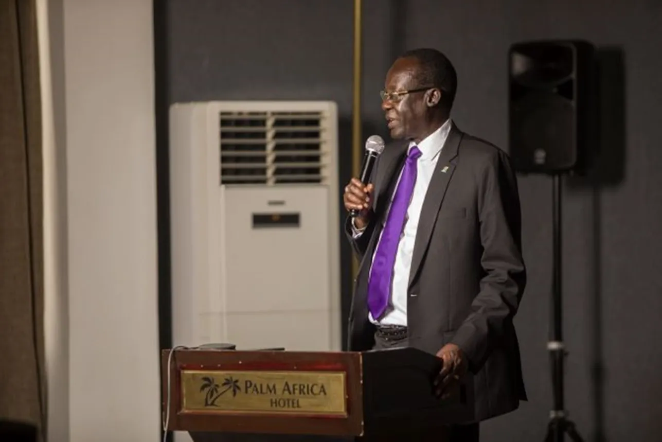 man speaking infront of an audience. 