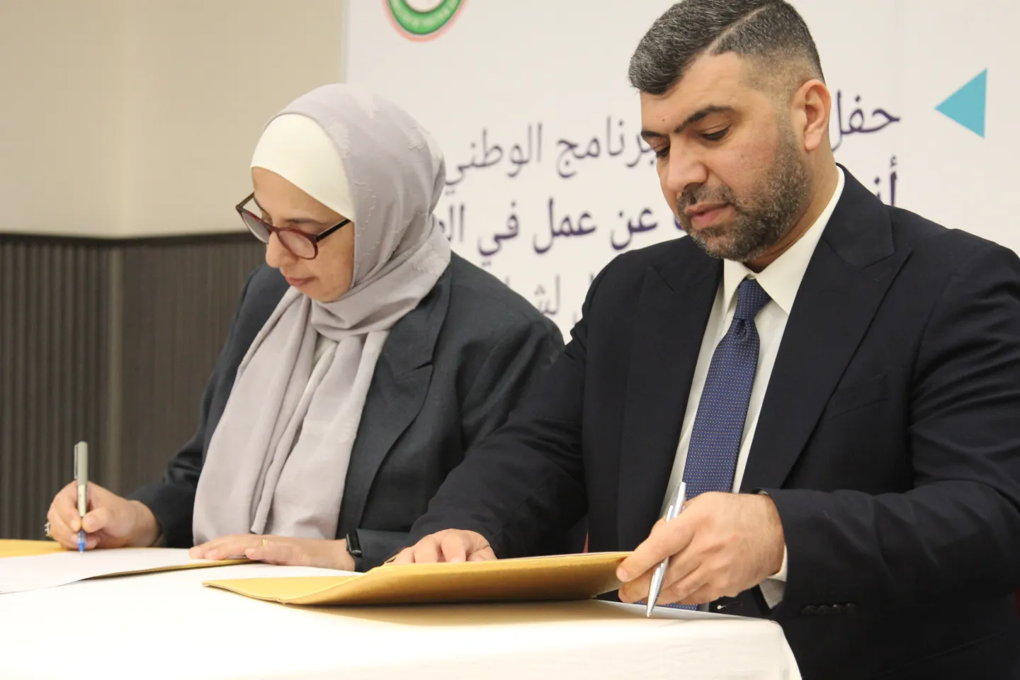 Dr. Ahmed Saad Aliwi, General Director, Ministry of Youth and Sports, and Dr. Maha Katta, Country Coordinator of the International Labor Organization in Iraq, signing the letter of intent