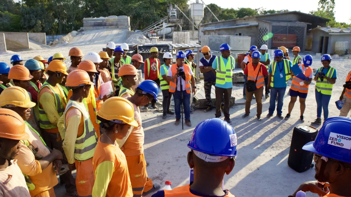 Construction workers crowd around ILO experts on Occupational Safety and Health during a presentation on OSH organized by the VZF Project in Madagascar.
