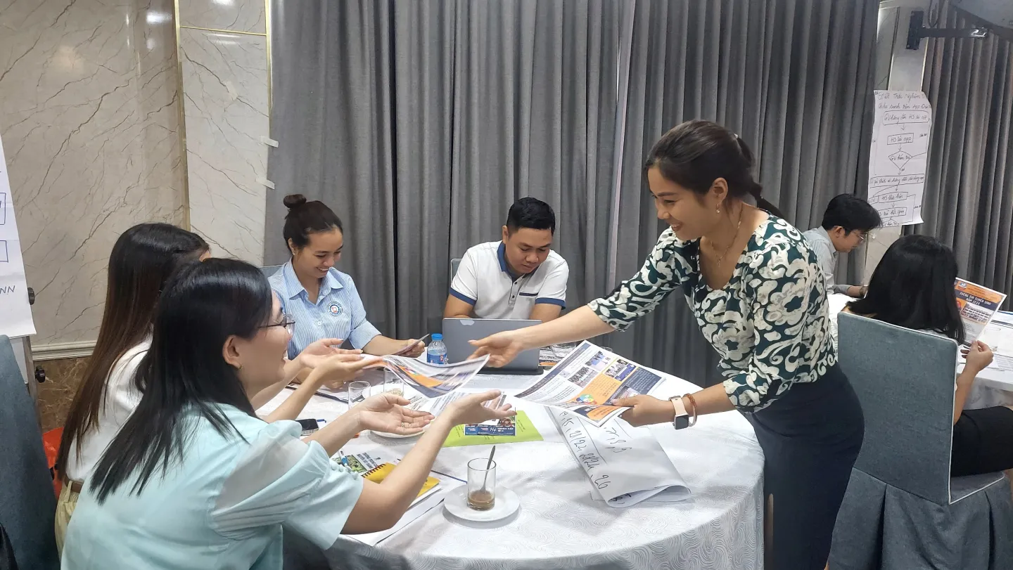 A participant shares flyers of a vocational training centre as part of a counselling practice session.