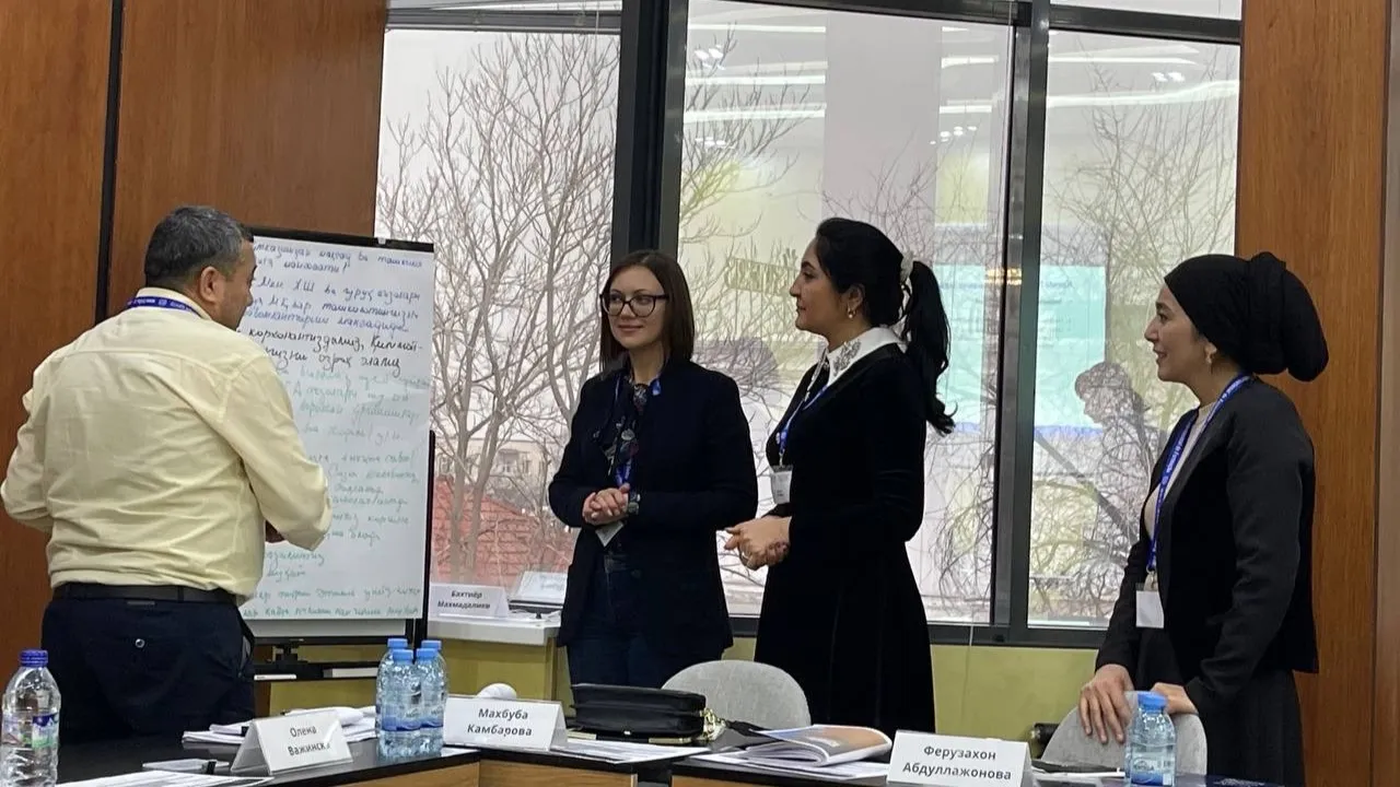 Four people standing in front of the flipchart during the ILO Participatory Gender Audit Facilitators Certification Course