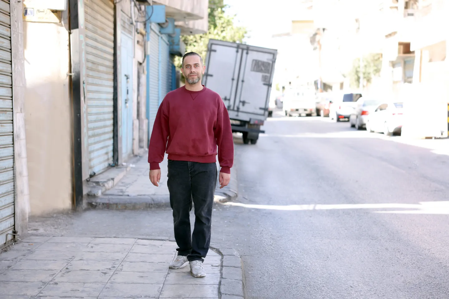 Eyad walks through his neighborhood in Zarqa. 