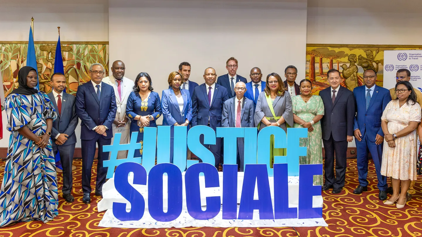 Photo de groupe des participants de haut niveau lors de la Journée Porte Ouverte de l'OIT, posant devant un grand panneau affichant le message « #JUSTICE SOCIALE », symbolisant leur engagement en faveur du travail décent et de la justice sociale.