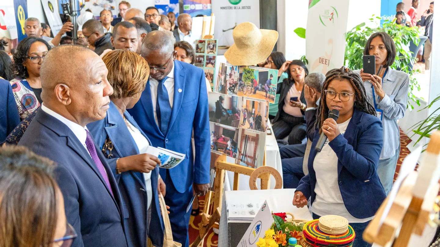 Le Premier ministre de Madagascar et d'autres responsables gouvernementaux visitant les stands de la Journée Porte Ouverte de l'OIT, échangeant avec une exposante présentant des initiatives locales.