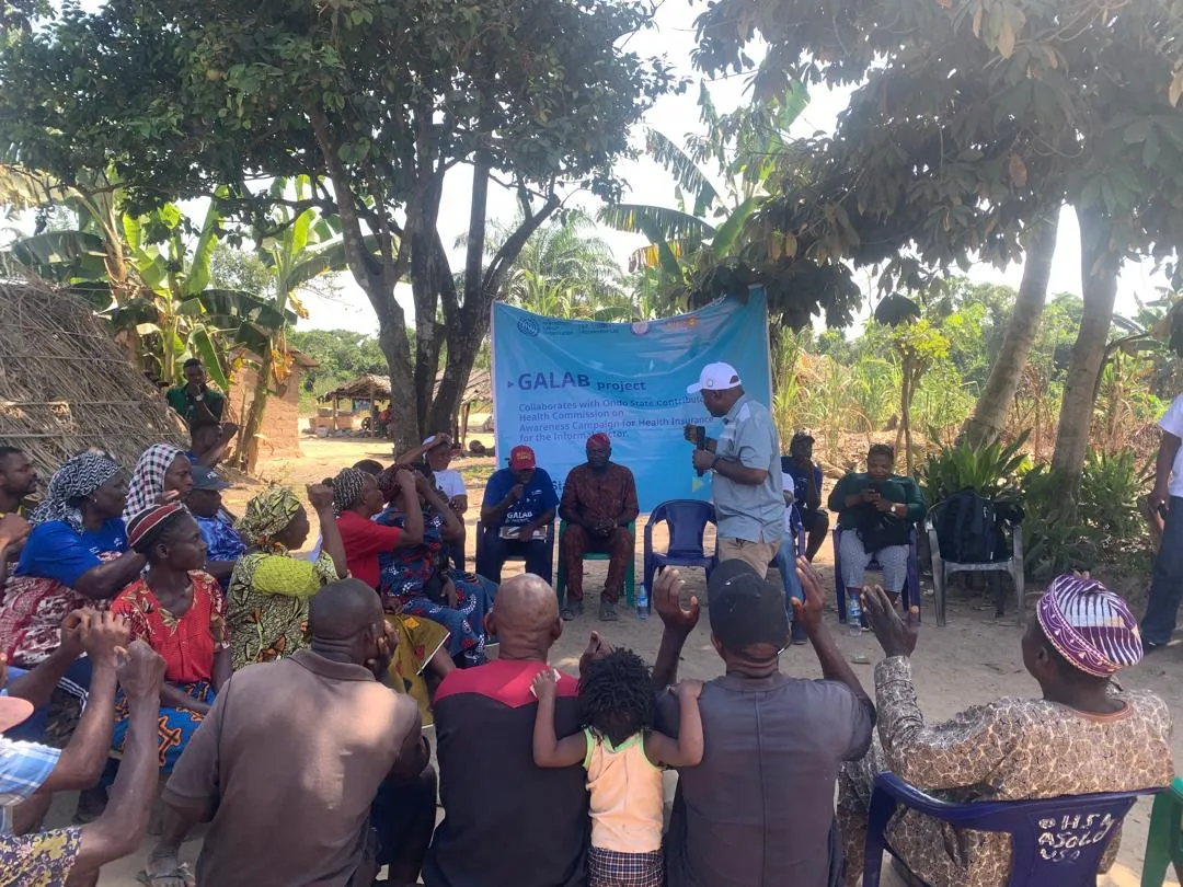 Community Members listening to a worker educating them on health insurance