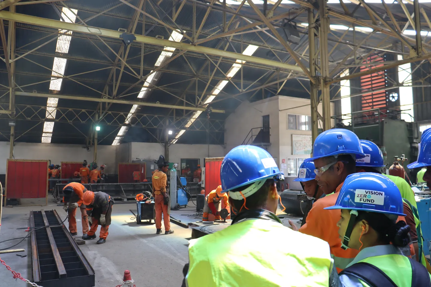 Group of people wearing protecting helmets, visiting a construction site