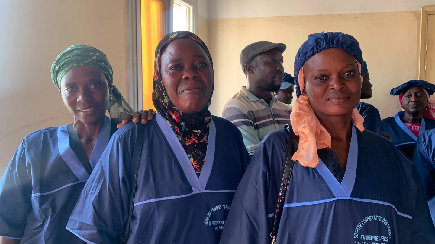 Membres d'une coopérative de femmes entrepreneures posant fièrement dans leurs tenues de travail.