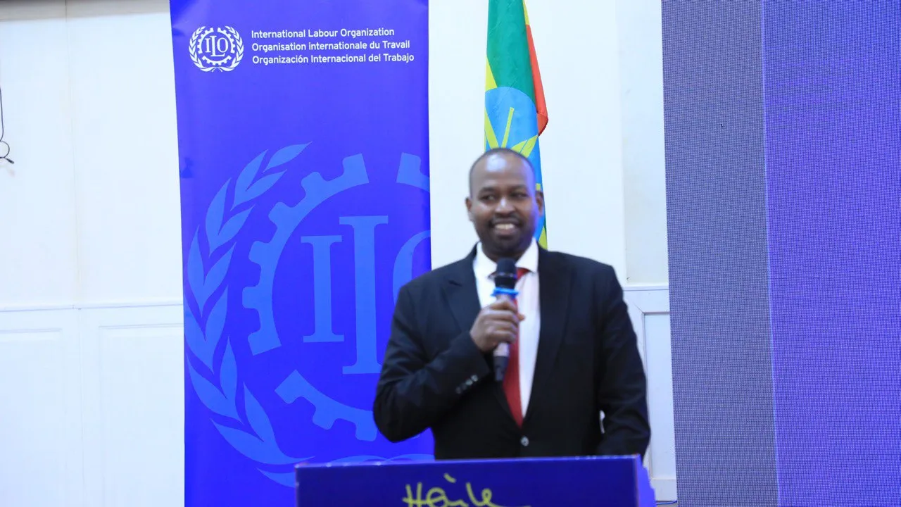 Man in a suit speaking with a microphone