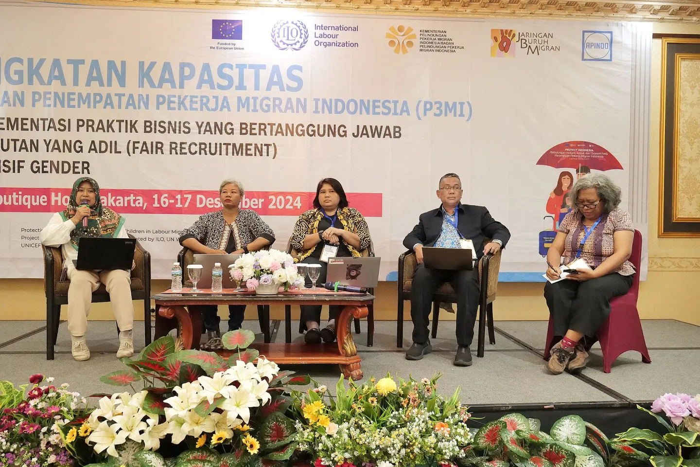 Four people sitting on the stage as resource persons