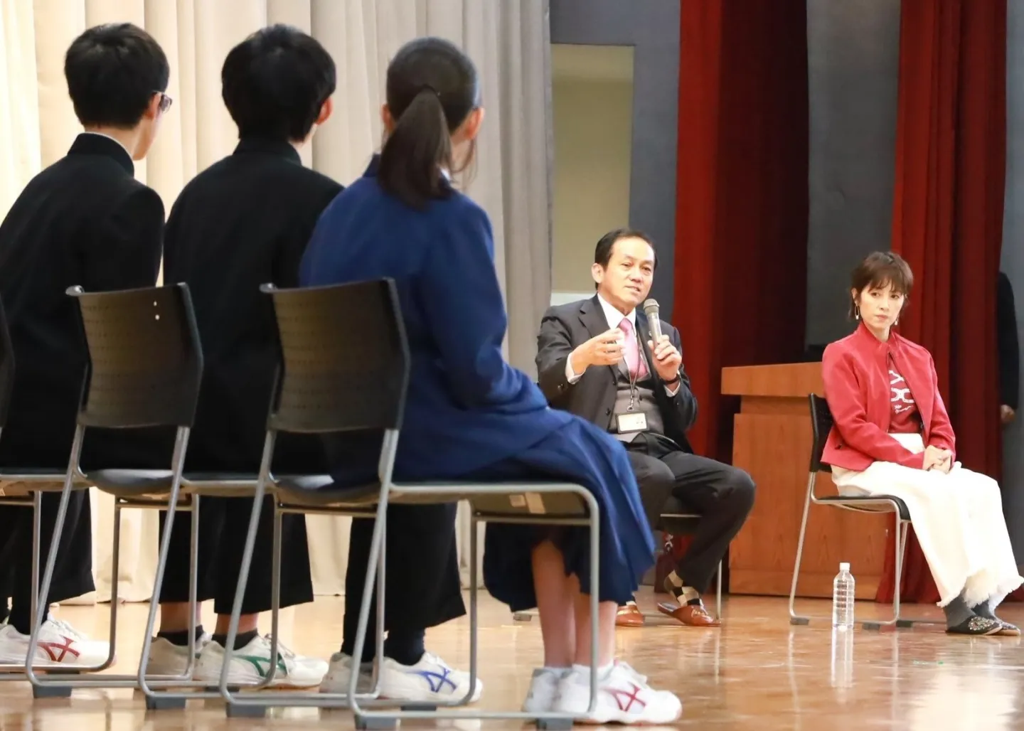 児童労働についての出張授業で歌手で「ILOサポーター」の荻野目洋子さん（後列右）と講演するILO駐日代表の高﨑真一＝2023年12月5日、千葉県佐倉市の市⽴井野中学校