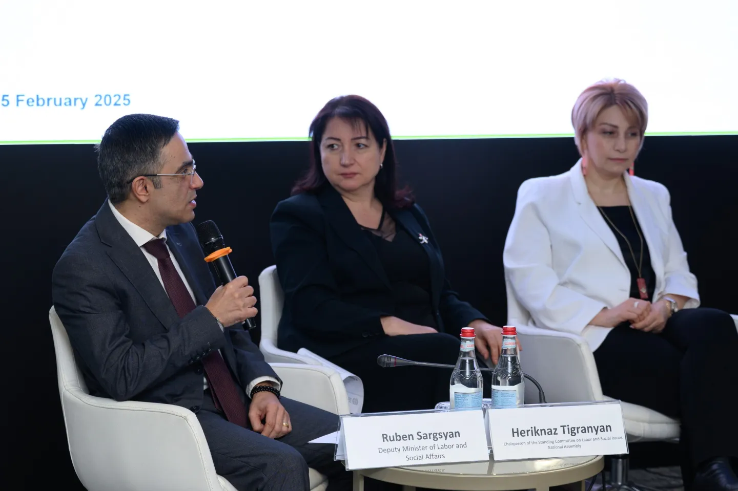 3 members of the panel sit in front of the screen with mics in hand during the high-level discussion on public works programmes (PWP) on 5 February 2025 in Armenia
