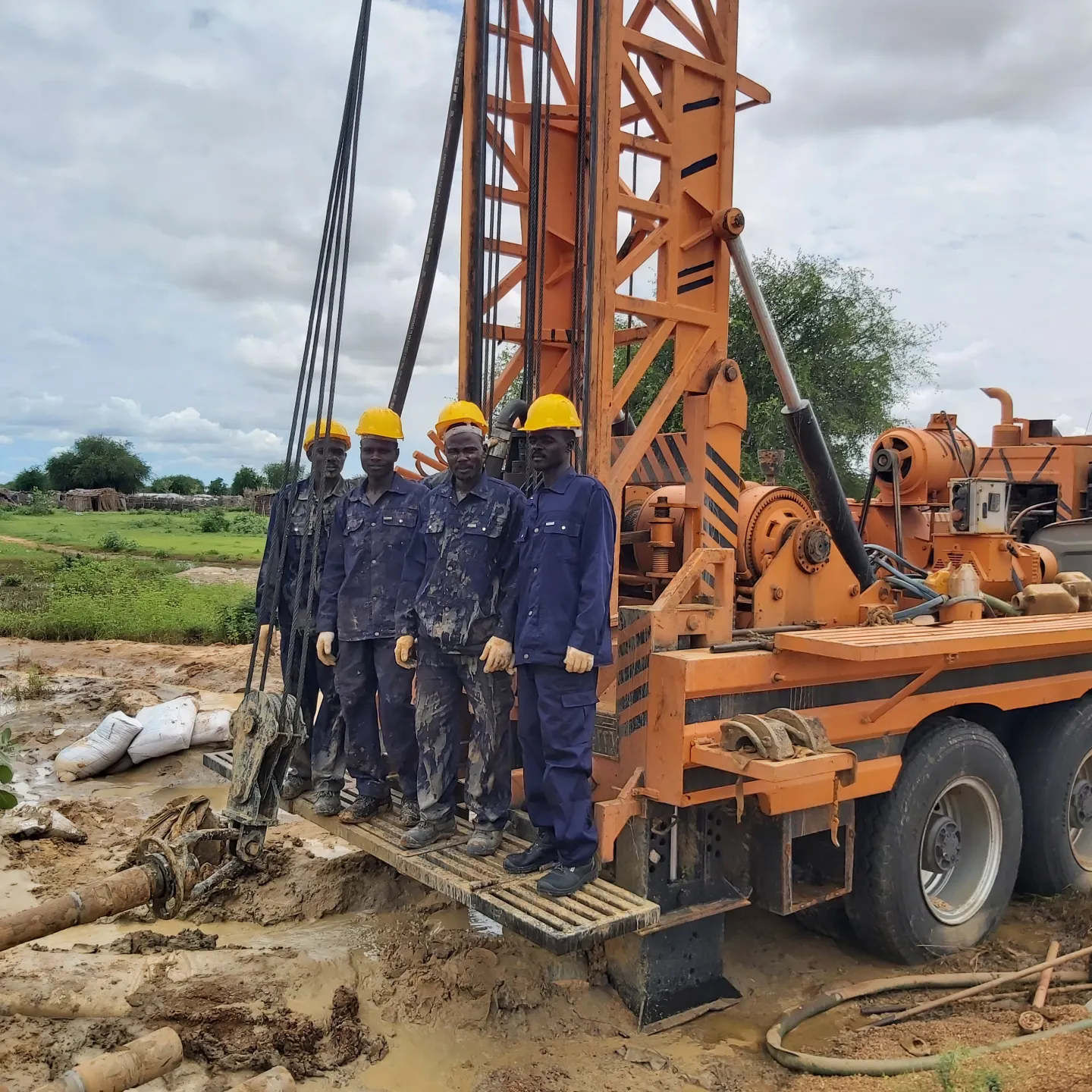 workers wearing uniform doing borewell digging work in sudan